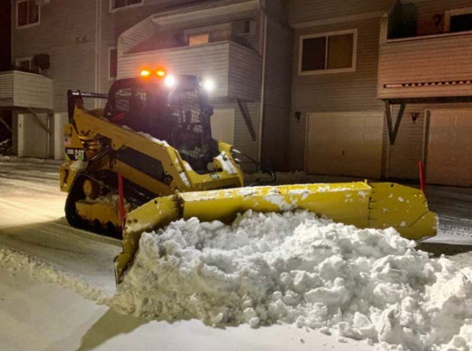 Compact track loader moving snow
